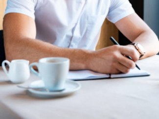 A man writing on a notebook